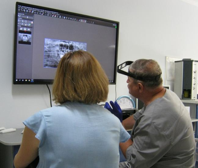 Стоматолог В.А.Власюк показує і пояснює пацієнтці щойно отримані результати КТ